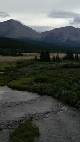 A Serene River Flows Through a Majestic Mountain Landscape in Alberta, Canada