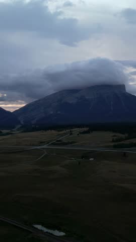 Majestic Mountain Peak Covered by Dramatic Clouds at Dusk in Alberta, Canada Wilderness Landscape