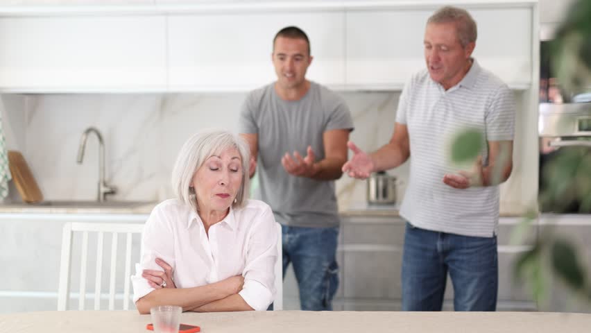  Adult woman sits at table and thinks how to resolve conflict with her husband and son. High quality 4k footage