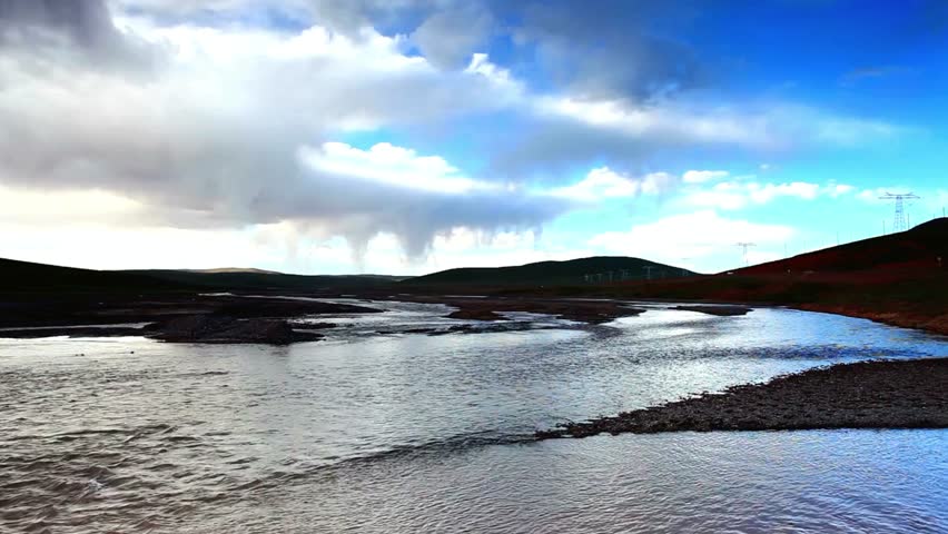Expansive river landscape under a dramatic cloudy sky