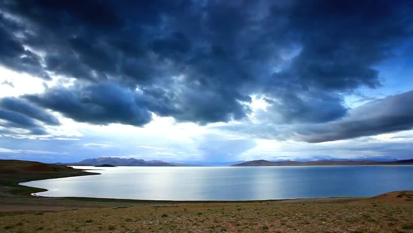 Dramatic clouds over a tranquil lake landscape in tibet