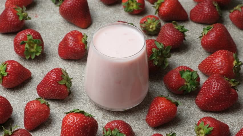 Milk drinking strawberry yogurt in a glass.