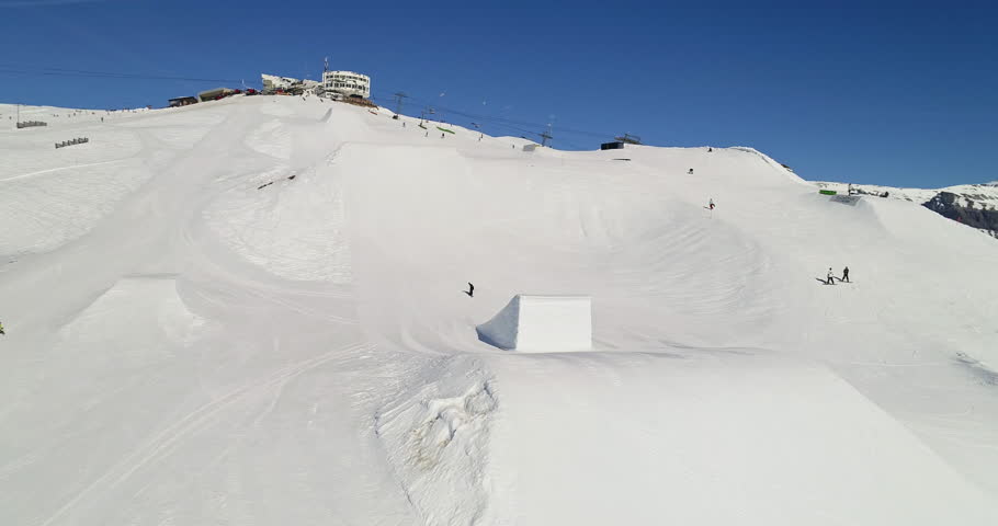Dynamic freestyle skier throwing big airs and stylish tricks on rails at Laax Snowpark, Switzerland—capturing high-level performance, style, and action in a world-class winter setting.