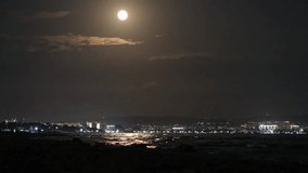 Full moon over sea and night city. Moon over town lights and water. Moonlight path on background of seaside with bright electric lights - Powered by Shutterstock - Get 15% off with code: PIKWIZARD15