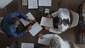 Top zoom-in shot of male medical clinic director in blue business suit talking to staff doctors during daily meeting, studying clinical recommendations on various drugs for patient treatment - Powered by Shutterstock - Get 15% off with code: PIKWIZARD15