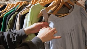 Second-hand shop. Close-up of young woman hands browsing clothes on hangers. - Powered by Shutterstock - Get 15% off with code: PIKWIZARD15