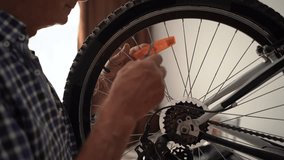Close-up of elderly man repairing bicycle indoors, securing reflector to wheel with screwdriver. cycle care, mechanical detail, and indoor DIY servicing. - Powered by Shutterstock - Get 15% off with code: PIKWIZARD15