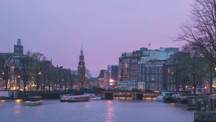Amsterdam Netherlands time lapse city skyline day to night at canal waterfront