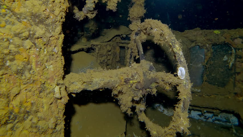 Close-up of truck cab lying on its side inside hold of wreck Salem Express ferry, Slow motion, Camera moving back from steering wheel in truck cabin, in luggage compartment of sunken ship