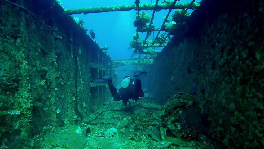 Scuba diver swimming along corridor of upper deck in wreckship of Salem Express ferry, Back view, Slow motion of diver swims along hallway on the deck of sunken ship
