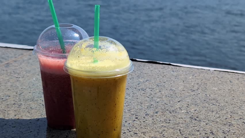 Berry and fruit smoothies cocktails in a bar on the sea or river bank, glasses with drinks close-up