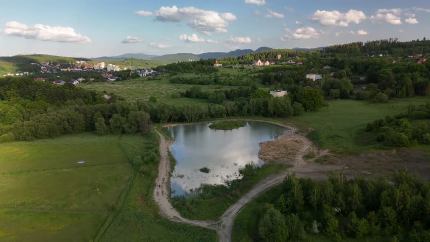 Aerial view of lush green valley, large lake and hills in mountainous region – summer landscape in Poland