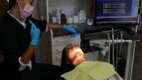 Dental hygienist finishing glove prep and initiating digital scanning rings around patient for exam. Clinical, technology, healthcare, dentistry, futuristic, instruments, patientcare - Powered by Shutterstock - Get 15% off with code: PIKWIZARD15