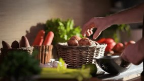 Close up of a hand carefully choosing fresh young potatoes from a rustic basket. A variety of other raw vegetables create a vibrant, healthy market scene. - Powered by Shutterstock - Get 15% off with code: PIKWIZARD15