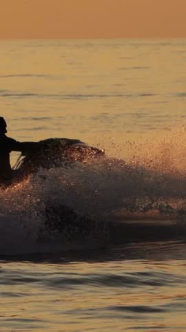 Silhouette of Man Riding Jet Ski at Sunset