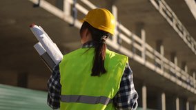 At a busy building site, a construction worker wearing safety gear diligently reviews detailed blueprints - Powered by Shutterstock - Get 15% off with code: PIKWIZARD15