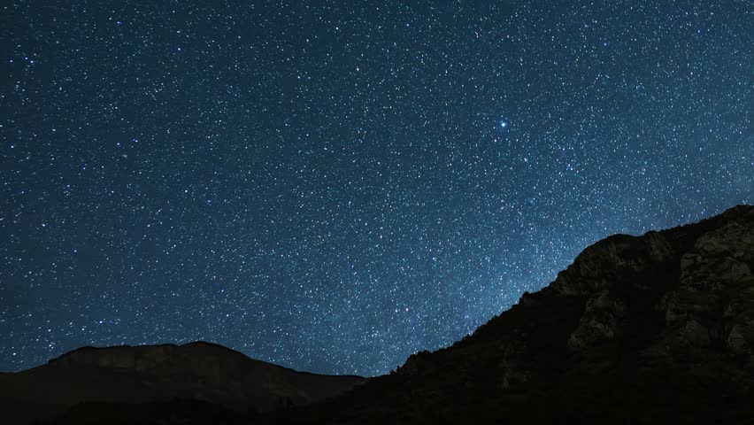 Beautiful night sky time lapse with Milky Way galaxy over mountain. Night tight landscape starry sky.
