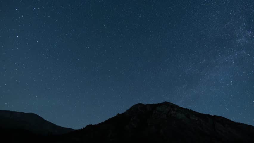 Beautiful night sky time lapse with Milky Way galaxy over mountain. Night tight landscape starry sky.