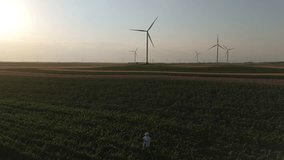 Farmer with digital tablet on agricultural field at sunset. Wind turbines in the background. Aerial view - Powered by Shutterstock - Get 15% off with code: PIKWIZARD15