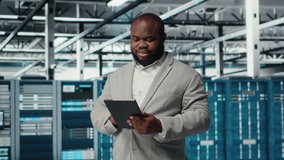 Cheerful data center programmer looking at code debugging tools running on tablet. Server farm IT professional typing on device touchscreen, writing script automating tasks, camera B - Powered by Shutterstock - Get 15% off with code: PIKWIZARD15