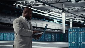 Cheerful data center system administrator reviews code for automation scripts. Jolly server room employee running diagnostics on equipment, doing predictive error detection, camera A - Powered by Shutterstock - Get 15% off with code: PIKWIZARD15