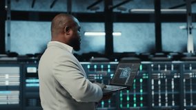 Programmer in data center using laptop, employing AI machine learning models. Worker using notebook to fulfill artificial intelligence infrastructure needs, allocating resources, camera B - Powered by Shutterstock - Get 15% off with code: PIKWIZARD15