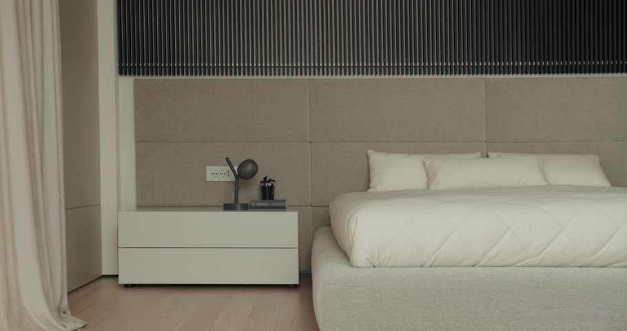 A minimalist and stylish bedroom featuring a comfortable bed with neutral toned bedding and a modern headboard. Elegant Bedroom Interior with Modern Design and Cozy Atmosphere