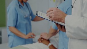 doctor flipping clipboard observing nurses adjusting IV amid digital overlay indicating vitals data. Medical teamwork, healthcare, clinical, data analytics, patient monitoring, hospital, innovation - Powered by Shutterstock - Get 15% off with code: PIKWIZARD15