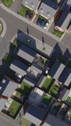 Vertical top down aerial view of new build suburban houses in the United Kingdom. Housing market and suburban lifestyle concept