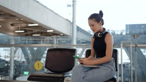 A positive Asian woman excitedly greets her friend at the airport, joyfully embracing and sharing stories in the bustling arrival area filled with travelers and memories. - Powered by Shutterstock - Get 15% off with code: PIKWIZARD15
