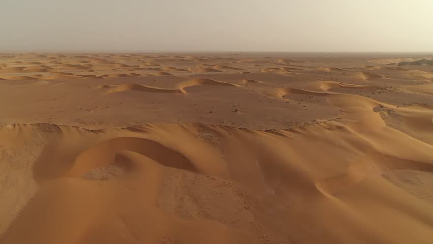 Aerial drone flies over landscape of endless, rolling sand dunes, horizon, El Agunia, Morocco in Africa, Sahara Desert, nature, vastness
