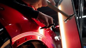 Close up view of Process of pointless dent repair on car body, mechanic at the auto shop with tools to repair dents in red car body. PDR - Powered by Shutterstock - Get 15% off with code: PIKWIZARD15