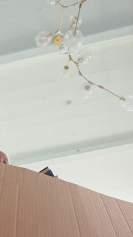 Young African American woman happily packs her belongings to move into a new home, exploring her unique style and organizing her living space.