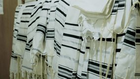 The tallit Jewish prayer shawls hanging neatly, in a synagogue or place of worship. The tallitot with knotted fringes tzitzit. - Powered by Shutterstock - Get 15% off with code: PIKWIZARD15