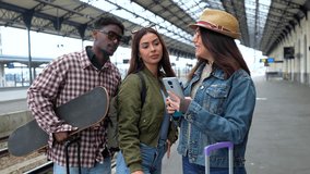 Multiethnic group of young friends smiling, capturing cheerful selfie moments while waiting on train station platform before exciting vacation journey - Powered by Shutterstock - Get 15% off with code: PIKWIZARD15