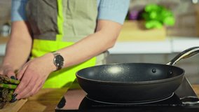 Woman frying asparagus for cooking on kitchen table. Frying it in pan. Closeup hands. Slow motion video with fast camera zoom. - Powered by Shutterstock - Get 15% off with code: PIKWIZARD15