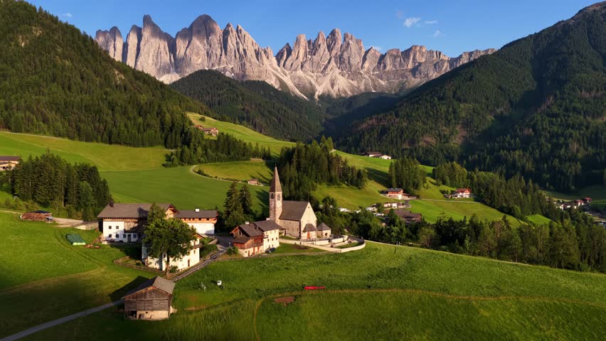Italian Dolomites iconic view, drone shot of church in Santa Maddalena at sunset in the Dolomites, Italy, Unesco world heritage site in the Italian Alps, idyllic alpine meadow