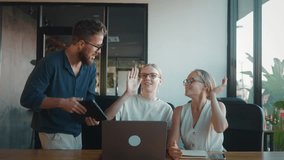 Happy business team exchanging high fives and celebrating successful completion of project in modern office workspace, radiating enthusiasm and collaboration. Successful team celebrates victory - Powered by Shutterstock - Get 15% off with code: PIKWIZARD15