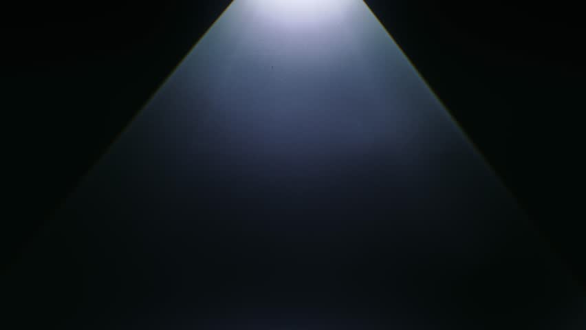 A silhouetted hand casts dramatic shadows in dim lighting, evoking mystery and creativity. Slow motion