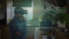 Senior man fitting VR headset at kitchen island, navigating metaverse with holographic rings. Technology, innovation, futuristic, digital, smart, elderly, home - Powered by Shutterstock - Get 15% off with code: PIKWIZARD15