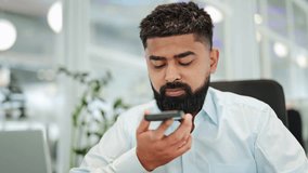 Indian businessman actively use smartphone voice assistant in bright modern office. Focused specialist intently records voice notes, demonstrating efficient communication technology for business tasks - Powered by Shutterstock - Get 15% off with code: PIKWIZARD15
