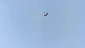 A kite with a long tail flying under a clear sky - Powered by Shutterstock - Get 15% off with code: PIKWIZARD15