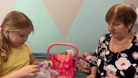 The child's grandmother smiles warmly as she sees her grandchild engrossed in playing with dolls, lost in a world of fantasy. - Powered by Shutterstock - Get 15% off with code: PIKWIZARD15