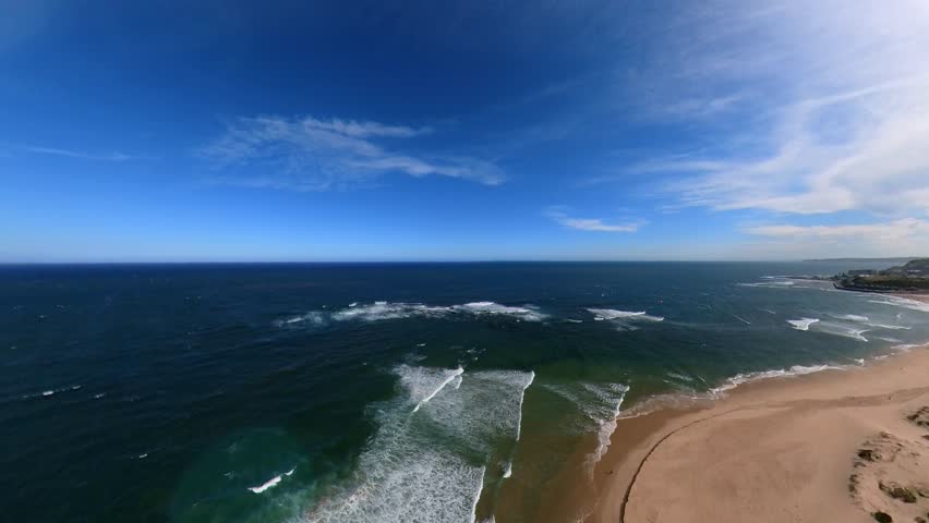Newcastle, New South Wales, Australia, nobbys breakwater stretching into the deep blue sea under a clear sky. The serene scene showcasing the harmony of ocean waves and sky hues