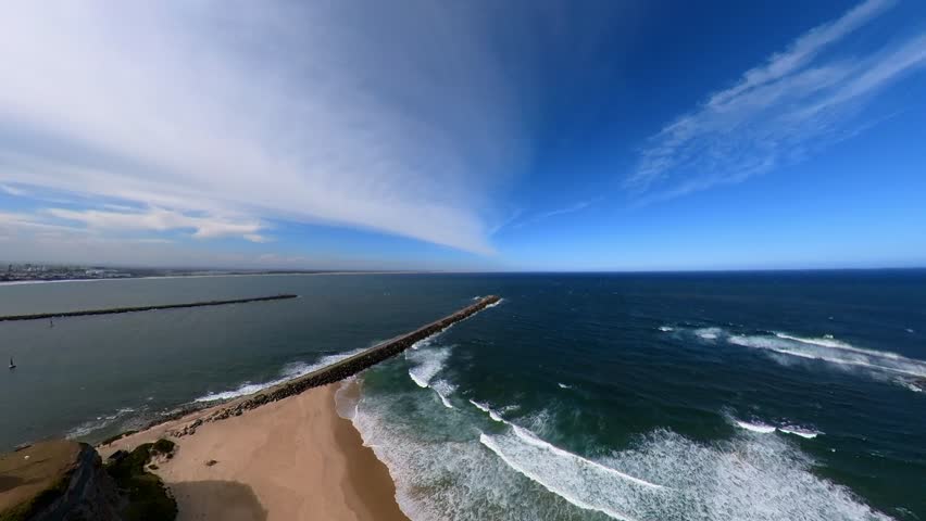 Newcastle, New South Wales, Australia, nobbys breakwater stretching into the deep blue sea under a clear sky. The serene scene showcasing the harmony of ocean waves and sky hues