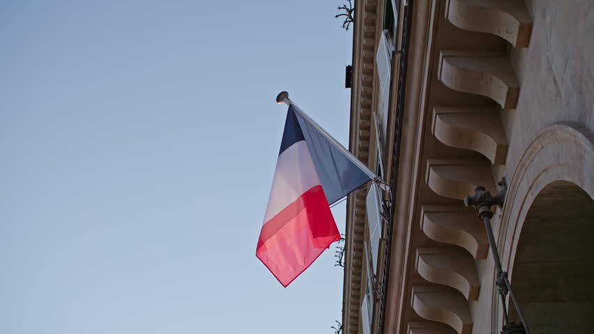 Close-up of the French flag fluttering in the wind. The flagpole on a building in Paris, the capital.