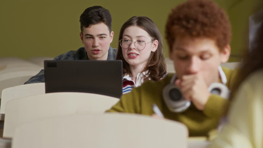 Rack focus of multicultural group of students taking notes while listening carefully during lecture in university - Powered by Shutterstock - Get 15% off with code: PIKWIZARD15