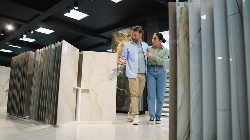 Couple choosing tiles with interior designer in showroom