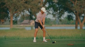 A male golfer takes a powerful swing in slow motion off the tee box. The background features a calm water view and glowing sunset, creating a cinematic moment of focus and energy on the course. - Powered by Shutterstock - Get 15% off with code: PIKWIZARD15