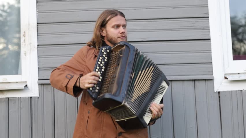 Male musician plays the accordion in the yard - Powered by Shutterstock - Get 15% off with code: PIKWIZARD15
